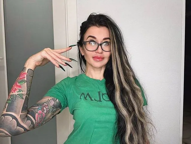 Fingerschnippen und Fingerlutschen mit grünen langen Nägeln, langen Haaren, Brille und Gesicht