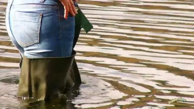 Alina in Jeans und Waders in tiefem Wasser